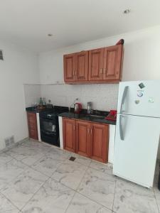 a kitchen with wooden cabinets and a white refrigerator at Departamento para 2 personas in Concordia