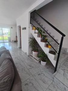 a living room with a staircase with potted plants at Departamento para 2 personas in Concordia