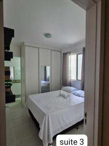 a bedroom with a white bed and a window at Edificio Versatto Residence in Belém