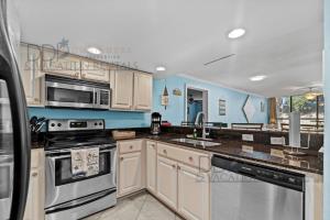 cocina con electrodomésticos blancos y paredes azules en Ocean Club Villa A-222, en Biloxi