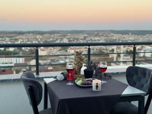 a cat sitting on a table with glasses of wine at BZN Airport Hotel in Arnavutköy