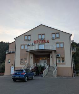 にあるRivera Raškaの大きな建物の前に停車する車 +11枚の写真