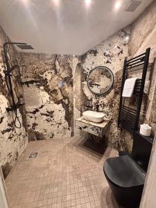 a bathroom with a toilet and a sink and a mirror at Woodhill Country House in Otterburn