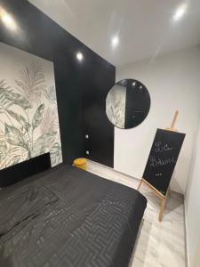 a bedroom with a black bed with a sign on the wall at La bohème C.A in Dijon