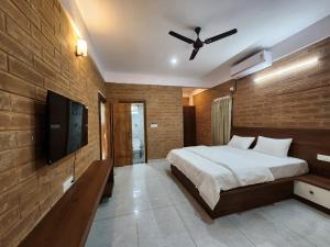 a bedroom with a bed and a ceiling fan at Brick House at Nandi in Bengaluru +6 photos
