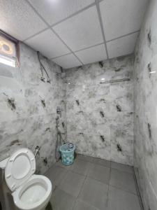 a bathroom with a toilet in a room at Brick House at Nandi in Bengaluru