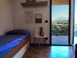 a bedroom with a bed and a view of a balcony at Panorama Etnea in Santa Maria di Licodia