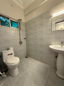 a bathroom with a toilet and a sink at Atlas Gold Hotel in Islamabad