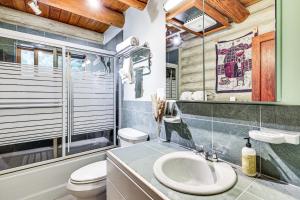 a bathroom with a sink and a toilet at Lake Margaret Access Boho Log Cabin with Backyard in Duvall +29 photos