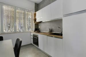a kitchen with white cabinets and a sink at Appartamento Carducci 213 in Marina di Pietrasanta