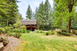 a house in the woods with a yard at Lake Margaret Access Boho Log Cabin with Backyard in Duvall