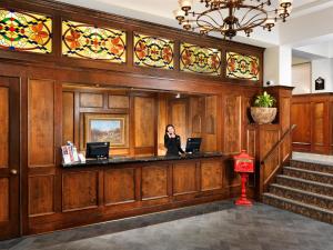 a woman standing at a counter in a building with stained glass at Huntingdon Hotel and Suites in Victoria