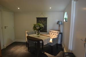 a dining room with a table and two chairs and a table and a tablektop at B&B Betuwezicht in Neerijnen