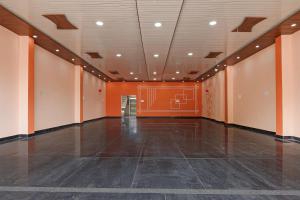 an empty room with an orange wall and an empty floor at SPOT ON SHREE JI HOTEL AND RESTAURANT Raipur Kukhat in Lonavala