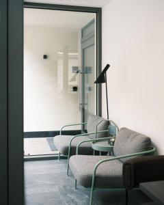 una sala de espera con sillas y un espejo en Smarthotel brenner24, en Brennero