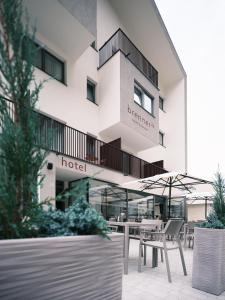 Un hotel con una mesa y sillas delante. en Smarthotel brenner24, en Brennero
