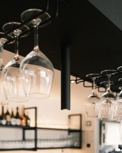 un montón de copas de vino colgando del techo en Smarthotel brenner24, en Brennero