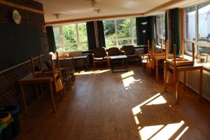 a room with chairs and tables and windows at Jugendhaus West in Spiekeroog +1 photo