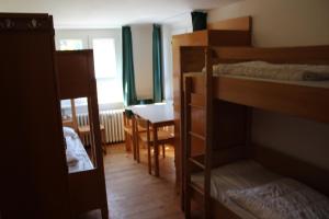 a room with two bunk beds and a table at Jugendhaus West in Spiekeroog