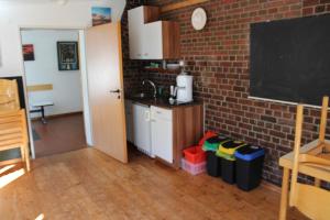 a kitchen with a sink and a blackboard in a room at Jugendhaus West in Spiekeroog