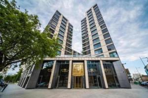 a building with two tall buildings in a city at Luxury Apartment Mennica Residence strefa wellness and sport by P&M in Warsaw