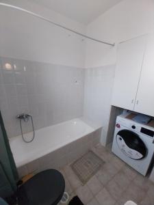 a white bathroom with a tub and a stove at Karamaniko in Episkopí +22 photos