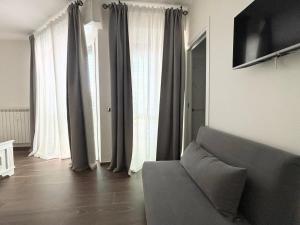 a living room with a couch and some curtains at San Siro House in Milan