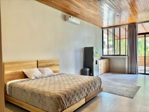 a bedroom with a large bed and a large window at NulaKai Boutique Apartments in Santa Teresa Beach +74 photos