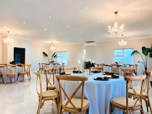 a dining room with tables and chairs and chandeliers at 435 on vale boutique aparthotel in Johannesburg +115 photos