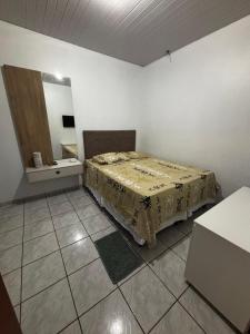 a bedroom with a bed with a table and a mirror at Microcasa 01 in Tangara da Serra