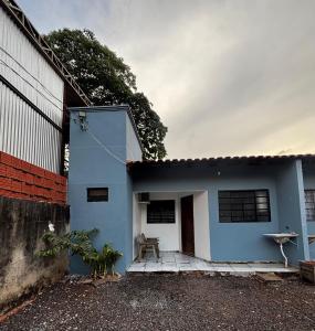 a blue and white house next to a fence at Microcasa 01 in Tangara da Serra