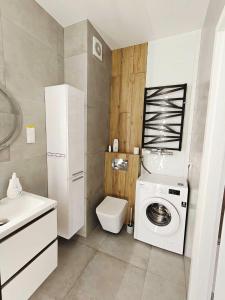 a bathroom with a washing machine and a toilet at Apartament Mono Ełk CENTRUM in Ełk +20 photos