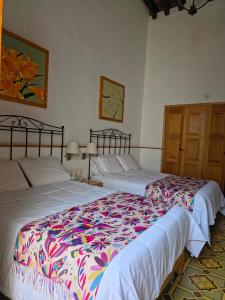 two beds sitting next to each other in a bedroom at Quinta María Hotel Boutique & Spa in Querétaro