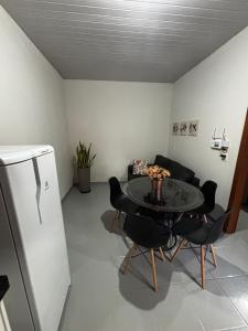a living room with a table and a refrigerator at Microcasa 02 in Tangara da Serra