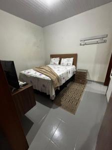 a small bedroom with a bed and a television at Microcasa 02 in Tangara da Serra