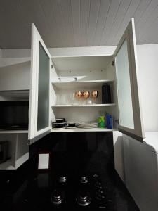 a kitchen with white cabinets and a black counter top at Microcasa 02 in Tangara da Serra