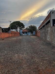 an empty street with a brick wall and trees at Microcasa 02 in Tangara da Serra +5 photos