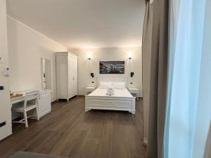 a white room with a bed and a desk at San Siro House in Milan