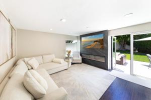 a living room with a white couch and a large window at 12 Mi to Disneyland! Sleek Suburban Home in Panorama Heights