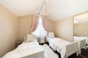 a bedroom with two beds and a mirror at 12 Mi to Disneyland! Sleek Suburban Home in Panorama Heights
