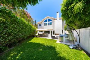 a yard with a white house with a fence at 12 Mi to Disneyland! Sleek Suburban Home in Panorama Heights