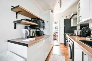Una cocina con gabinetes blancos y un refrigerador negro. en Riverside 1 Bed Flat with Parking at Kingston, en Kingston upon Thames