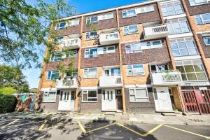 un edificio de apartamentos con puertas y ventanas blancas en Riverside 1 Bed Flat with Parking at Kingston, en Kingston upon Thames