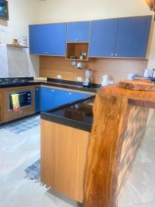 a kitchen with blue cabinets and a wooden counter top at Sítio metamorfose in Piranguçu +4 photos