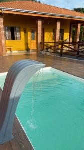 a swimming pool in front of a house at Sítio metamorfose in Piranguçu