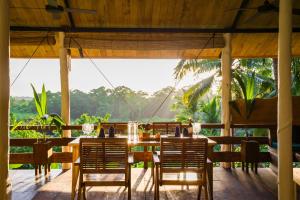 ハヴロック島にあるSatya Boutique Resort & Spaのテーブルと椅子、そして大きな窓のあるダイニングルーム