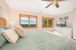 ein Schlafzimmer mit einem Bett und einem Fernseher und Fenstern in der Unterkunft Reel Chill- 4 bedroom home with Dock, Swimspa, Hot tub! in Thayerville + 38 Fotos