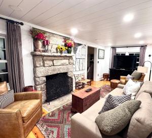 un salon avec un canapé et une cheminée dans l'établissement Stay Foxy Cottage, Mirror Lake Highlands, NC, à Highlands