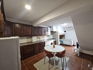 a kitchen with a white table and a white refrigerator at Nisa 2 Bedrooms AC Villa in Nisa