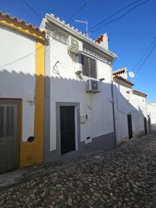 a white building with a yellow and white door at Nisa 2 Bedrooms AC Villa in Monte Claro